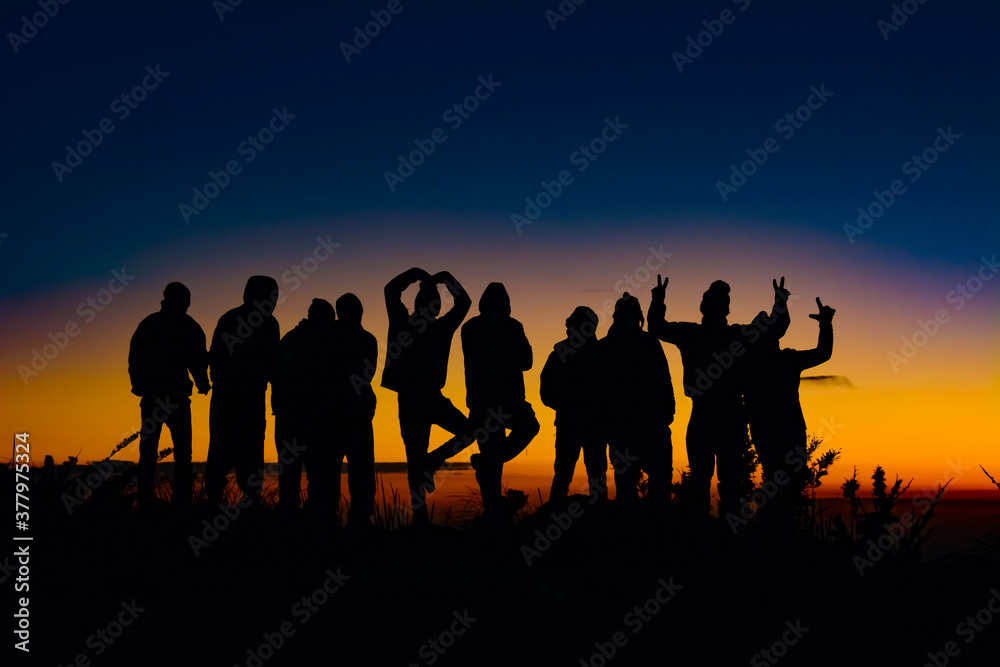 silhouettes of people together in a beautiful sunset at the mountain