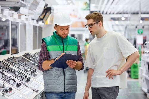 Obraz na plátně customer want new stove for home, he gets consultation by confident warehouse wo