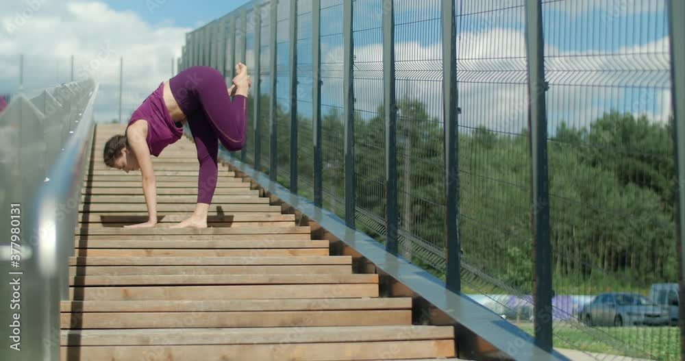 Athletic woman does stretching exercises at the handrails of street stairways , fitness in the urban environment, yoga class outdoors, physical workout in the city, 4k 60p Prores HQ Athletic woman does stretching exercises at the handrails of street stairways , fitness in the urban environment, yoga class outdoors, physical workout in the city, 4k 60p Prores HQ