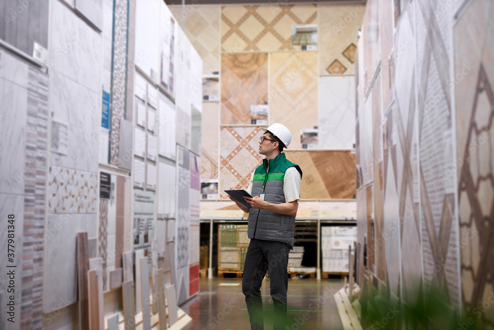 concentrated young warehouse worker in production department of modern store, take notes. export, logistics concept concentrated young warehouse worker in production department of modern store, take notes. export, logistics concept
