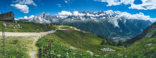 Panoramic aerial view of a city in the French Alps surrounded by mountains on a cloudy day
