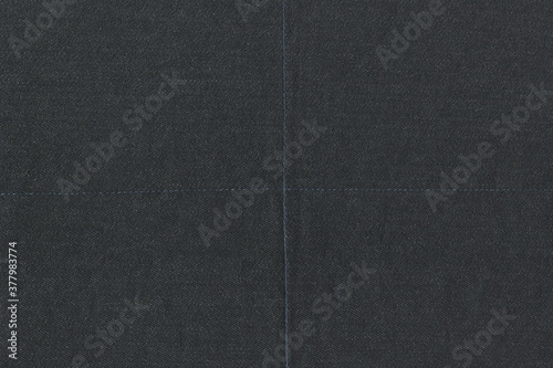 Texture of rough natural dark denim. Dark-colored cotton burlap with a cross stitch. photo