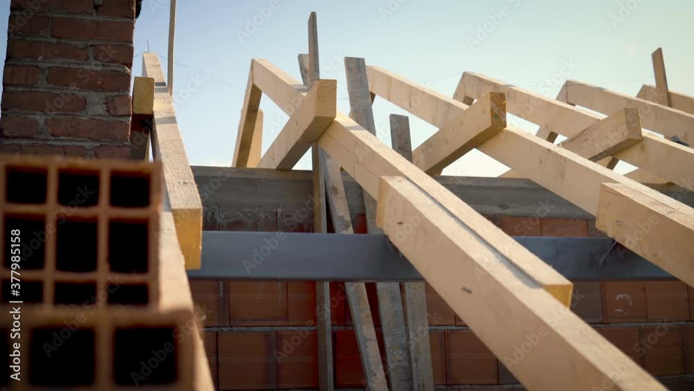 Installation of wooden beams at construction the roof truss system of the frame house Installation of wooden beams at construction the roof truss system of the frame house