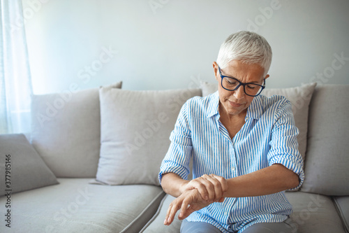 Elderly lady is enduring strong ache. Elderly woman suffering from pain in hand, closeup. Elderly female is expressing pain. Woman suffering from pain From Rheumatoid Arthritis