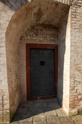 Entrance metal door to the basement. There is a wall around. © Roman Bjuty