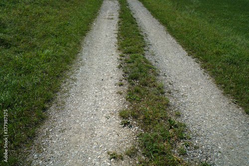 Top view of an unpaved road with grass on sides