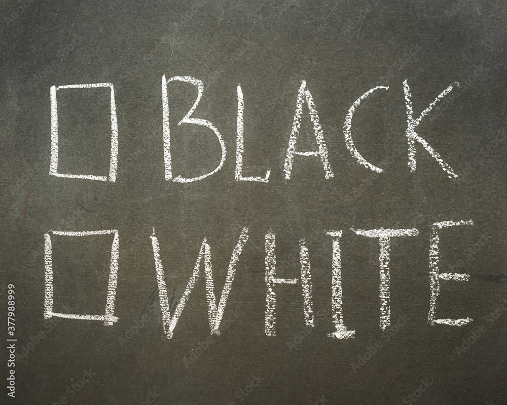 Fototapeta premium Questionnaire written in chalk on a blackboard with the words black or white