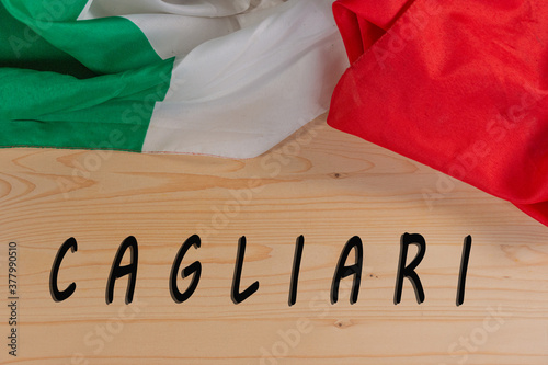 Italian flag isolated on wooden background with lettering of famous Italian cities