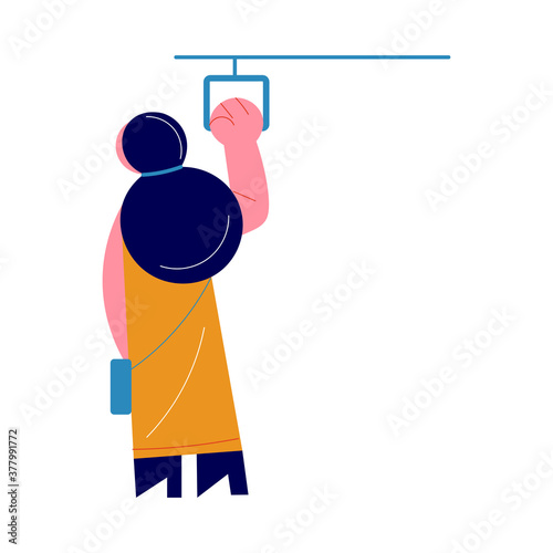 Woman standing in subway coach and holding on to handrail