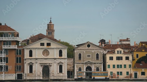 Venetian waterfront shot from moving tourist boat in spring season.Popular tourist destination in Italy.Ancient city of Venice in motion.Famous place for travel in Europe