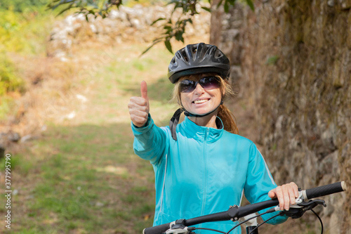 woman with bicycle and helmet outdoors