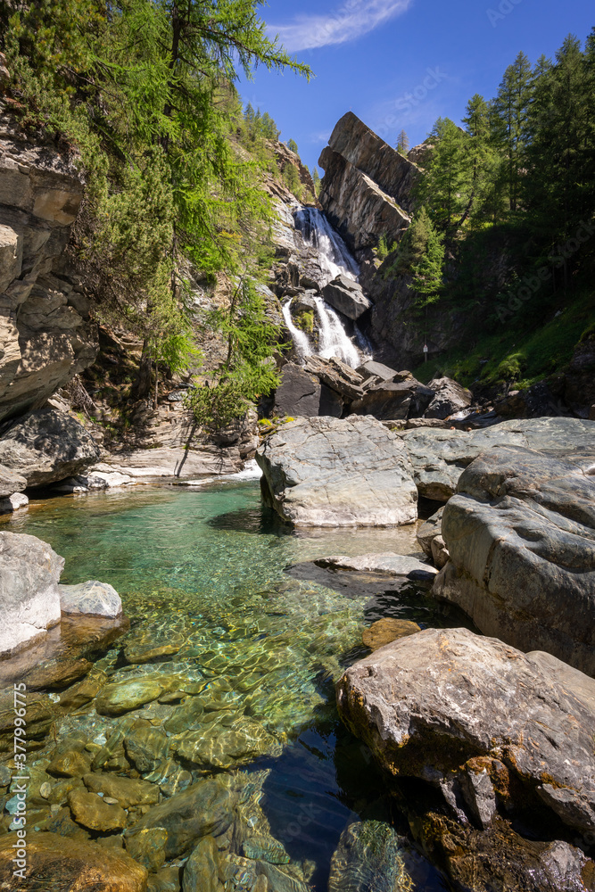 Fototapeta premium l'eau limpide d'une rivière avec une cascade en arrière plan