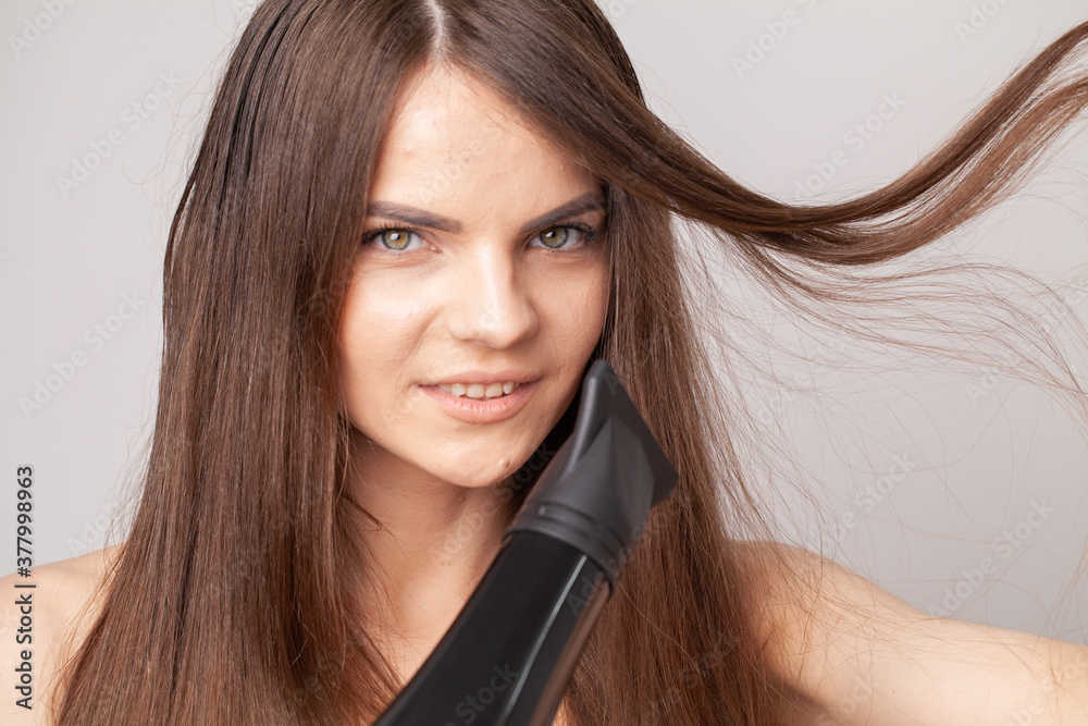 Beautiful Smiling Girl With Blonde Long Straight Hair Using Hairdryer. Beautiful Smiling Girl With Blonde Long Straight Hair Using Hairdryer.