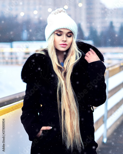 Obraz na płótnie Blonde girl posing during the snowfall at the city w salonie