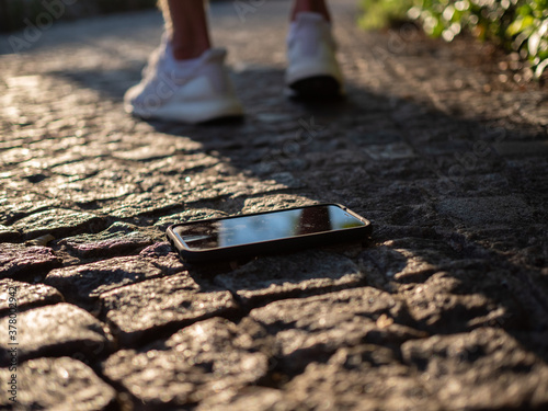 A man walking away after losing his phone on the sidewalk