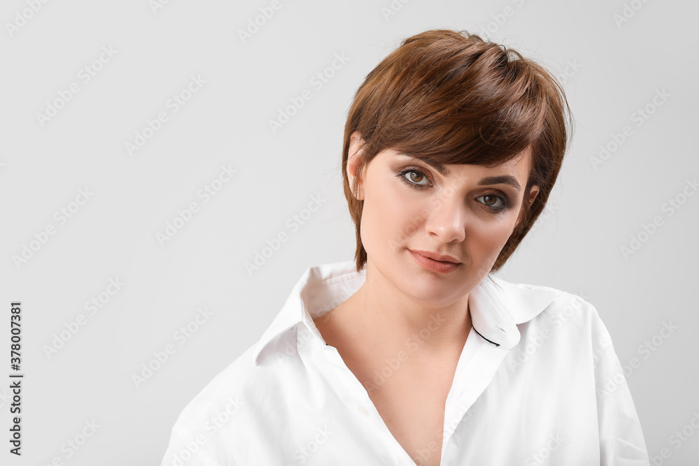 Young woman with beautiful short hair on grey background Young woman with beautiful short hair on grey background