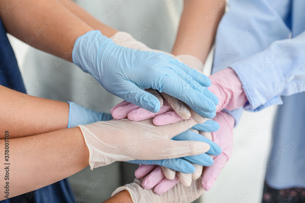 Team of doctors putting hands together. Unity concept Team of doctors putting hands together. Unity concept