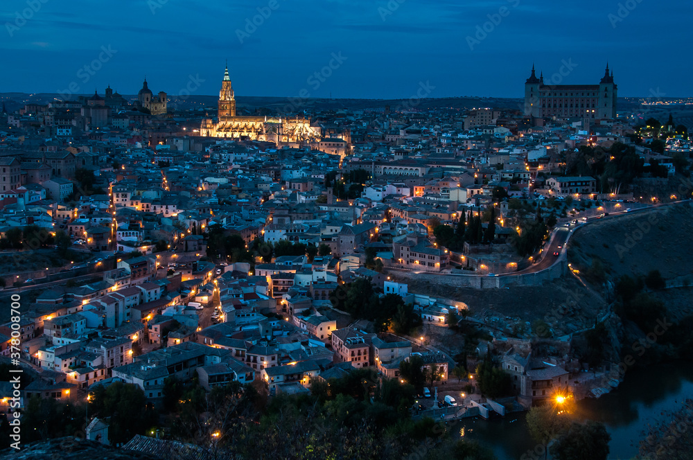 Vista de la ciudad de Toledo, España, al anochecer, con las luces iluminando la Catedral. Vista desde el Parador Nacional, en la otra orilla del río Tajo.