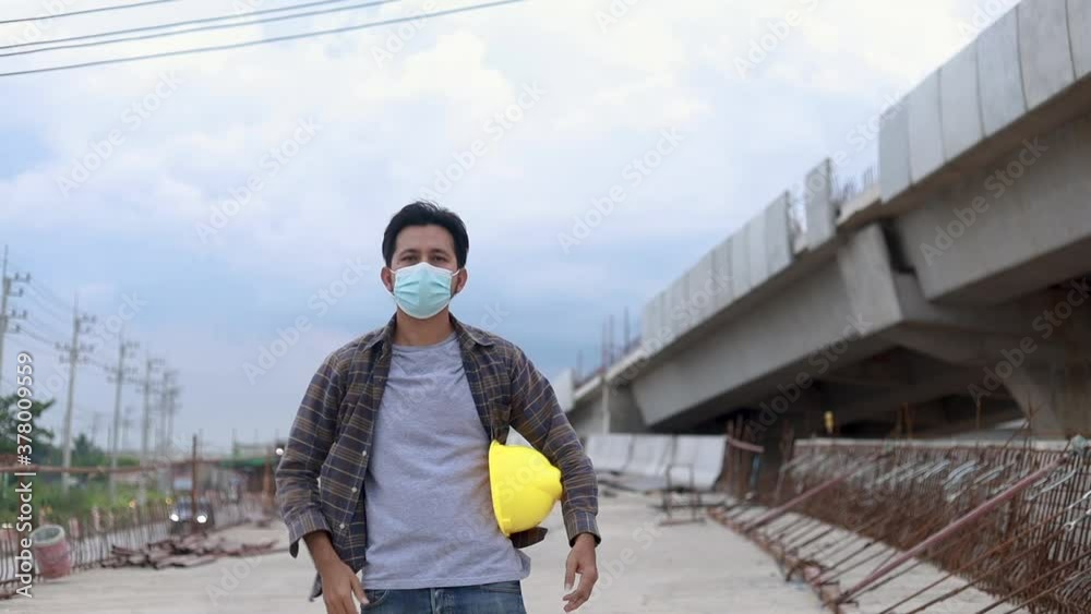 Construction workers walking wear protective face masks and safety helmet in construction site slow motion Construction workers walking wear protective face masks and safety helmet in construction site slow motion
