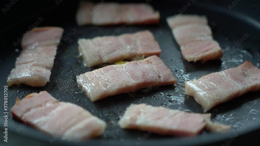 Fry the bacon pieces in a pan. Crispy pieces of delicious bacon are fried in a hot skillet. Fry the bacon pieces in a pan. Crispy pieces of delicious bacon are fried in a hot skillet.