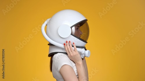 Woman with space helmet on her head on orange background. photo