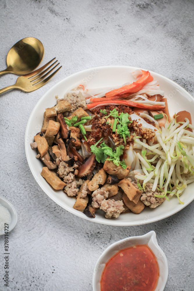 Chinese Steamed Rice Noodles with pork ,sausage,imitation Crab Stick,boil bean sprouts,mushroom and tofu in sweet soy sauce.Chili powder,pickled chili and sugar on table - asian food style Chinese Steamed Rice Noodles with pork ,sausage,imitation Crab Stick,boil bean sprouts,mushroom and tofu in sweet soy sauce.Chili powder,pickled chili and sugar on table - asian food style