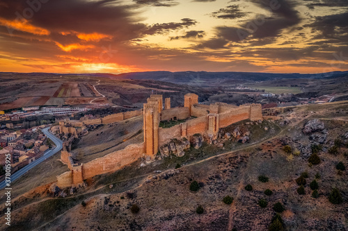 Aerial dramatic sunset view Moline de Aragon large Gothic castle ruin in central Spain with towers and walls built on Moorish origins photo