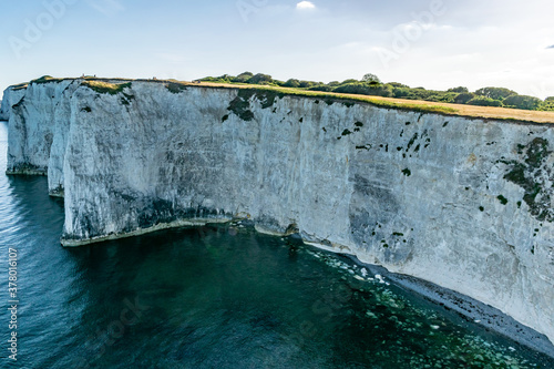 Old Harry Rocks chalk formations, view at Handfast Point, Dorset, southern England. Huge wall of white chalk cliffs with stumps and caves, tourist destination coastal view by the sea in south UK photo