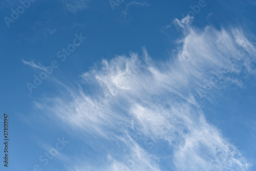 Fresh air, bright blue sky with wispy white clouds, as a nature background 
