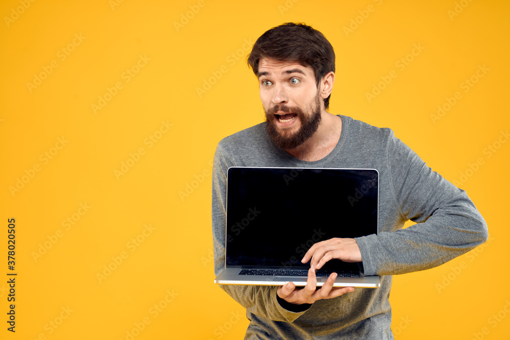 man with laptop wireless technology internet lifestyle work yellow isolated background