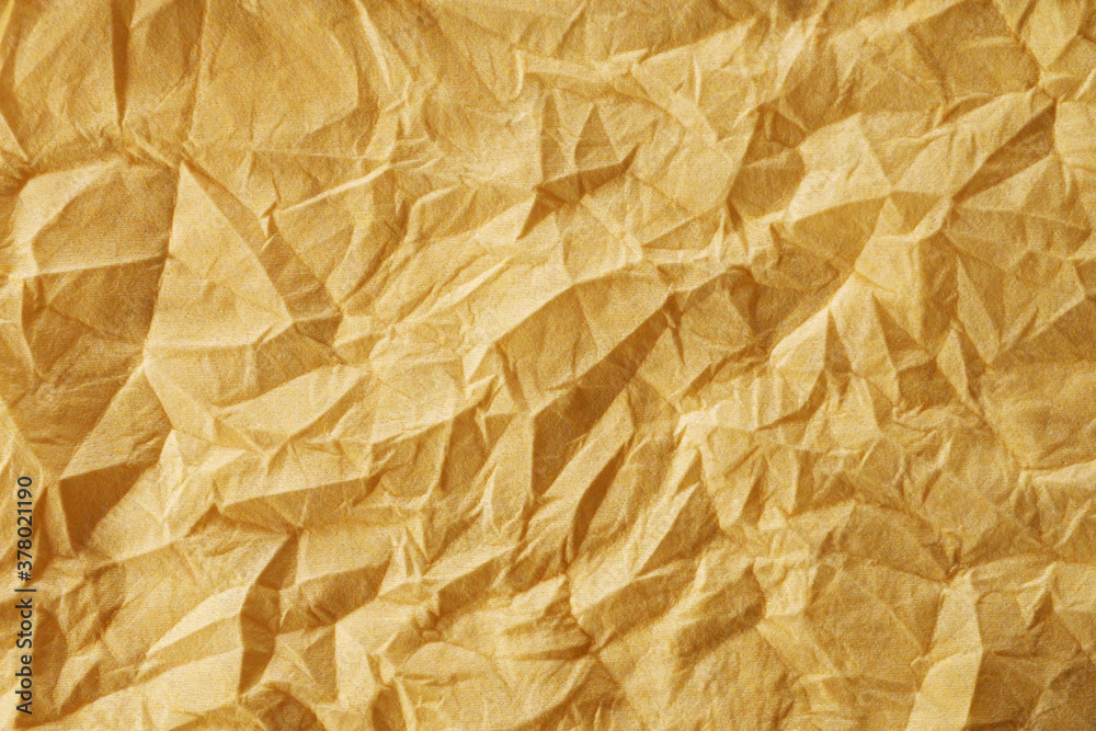 Obraz premium The texture of a crumpled yellow-gold disposable textile napkin.