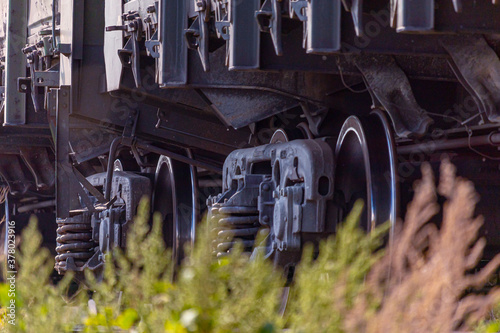Wheels of a railway train driving through the fields close up