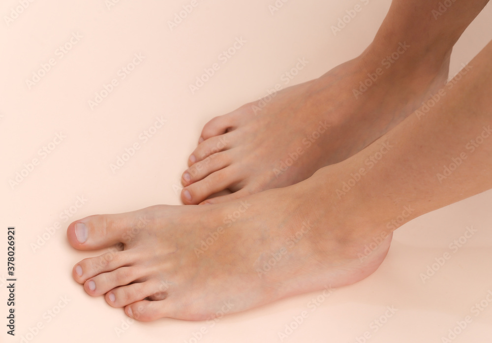 Female bare feet on a beige background. Beauty Care Concept