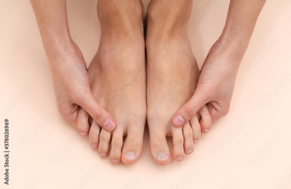 Female bare feet on a beige background. Beauty Care Concept Female bare feet on a beige background. Beauty Care Concept