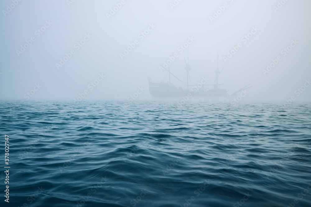 Obraz premium Fog over the sea waves, and misty ship on a background