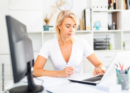 Successful adult business woman using laptop at workplace