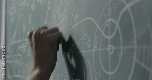 Creative mathematician writing formulas on the chalkboard