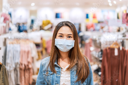 Young Asian woman wearing surgical mask shopping in clothes stores at the mall, New normal and lifestyle concept