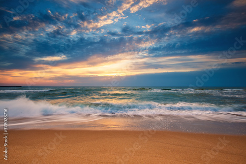 Fototapeta Naklejka Na Ścianę i Meble -  Beach sunrise over the sea and dramatic clouds