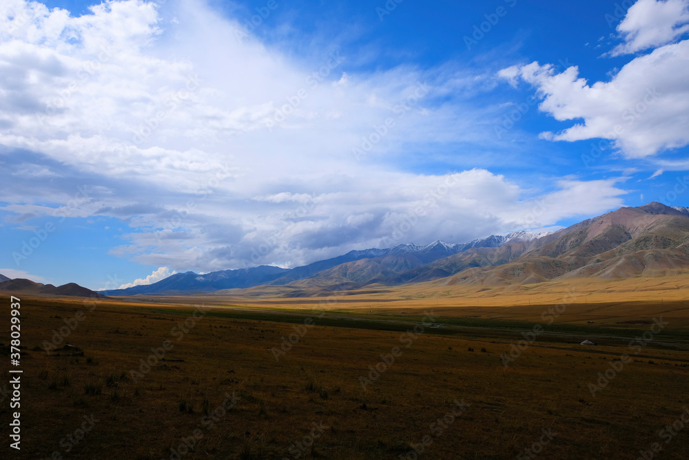 Mountain plateau with cloudy blue sky on background. Rural scenery. Summer nature landscape. Borokhudzir plateau, Kazakhstan. Tourism in Kazakhstan concept.