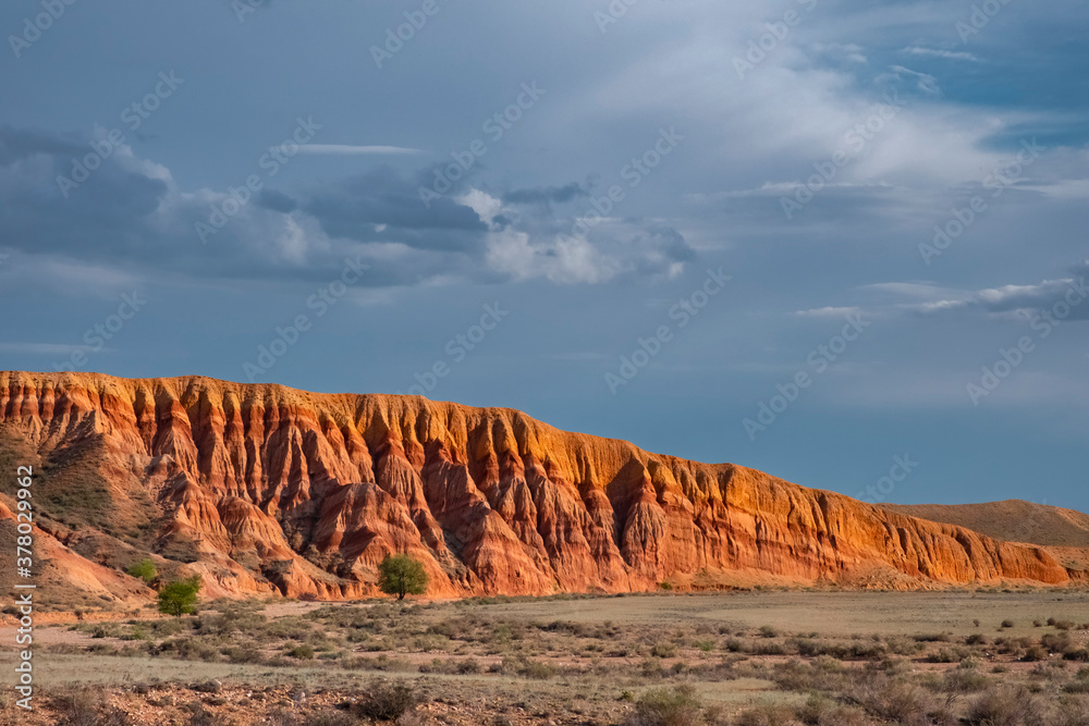Red sandstone mountain formation with cloudy sky on background. Outdoor landscape. Red sandstone mountain formation with cloudy sky on background. Outdoor landscape.