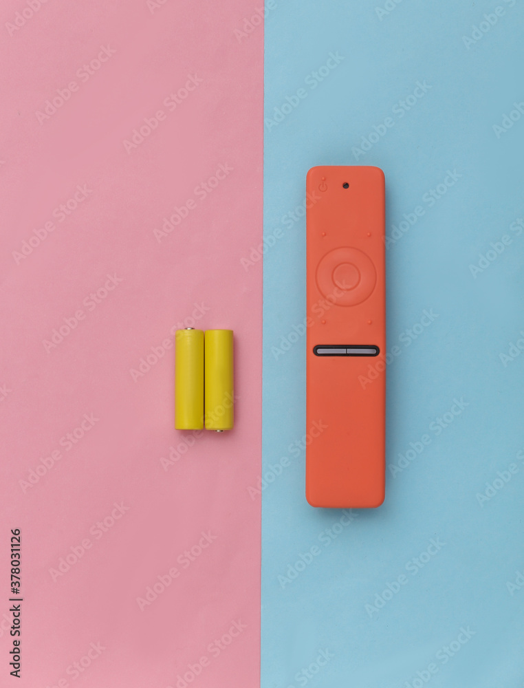 Tv remote and two batteries on a blue-pink pastel background. Top view Tv remote and two batteries on a blue-pink pastel background. Top view