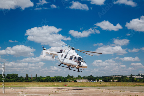 A white helicopter takes off from the runway