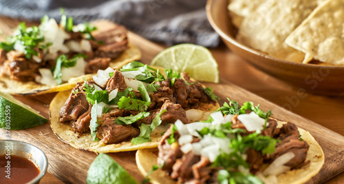 three carne asada mexican street tacos in corn tortilla with lime photo