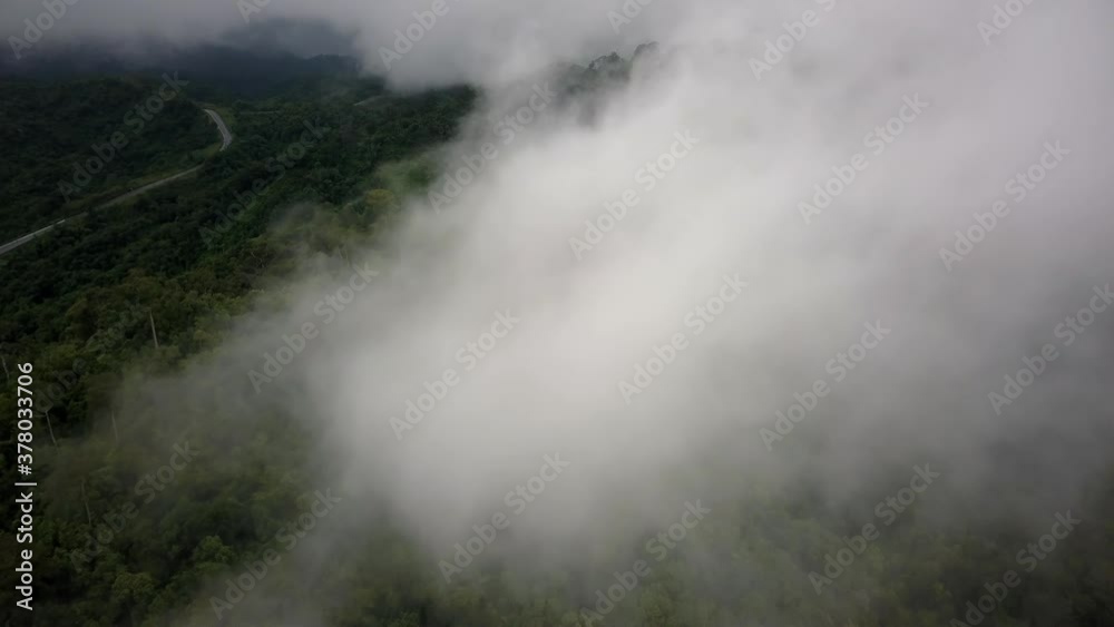 Aerial view flying above lush green tropical rain forest mountain with rain cloud cover during the rainy season on the Doi Phuka Mountain reserved national park the northern Thailand Aerial view flying above lush green tropical rain forest mountain with rain cloud cover during the rainy season on the Doi Phuka Mountain reserved national park the northern Thailand