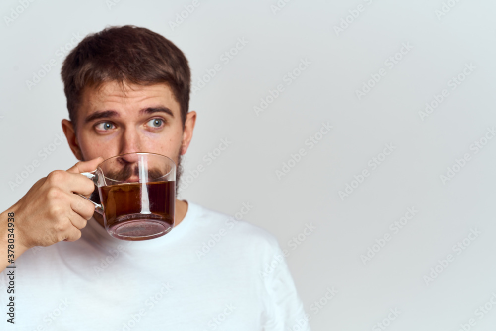 man drinking brewed tea from a cup and light background cropped view Copy Space man drinking brewed tea from a cup and light background cropped view Copy Space