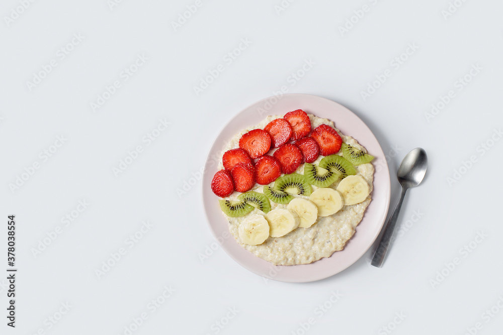 Concept of food for healthy breakfast. oatmeal with bananas, kiwi and strawberry on light background. Top view. Copy space Concept of food for healthy breakfast. oatmeal with bananas, kiwi and strawberry on light background. Top view. Copy space