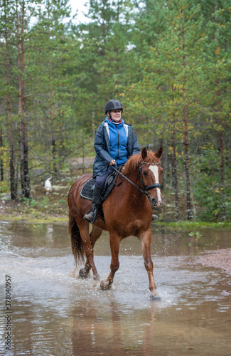 Woman horseback riding in water  © citikka