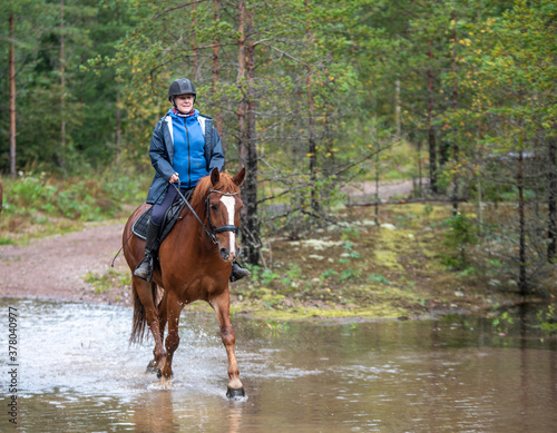 Woman horseback riding in water 