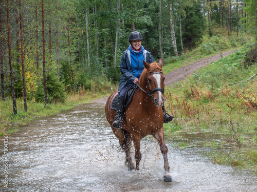 Woman horseback riding in water 